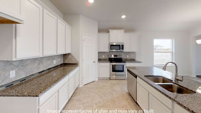 Kitchen featuring stainless steel appliances, a sink, recessed lighting, white cabinetry, and dark stone counters | Image 8