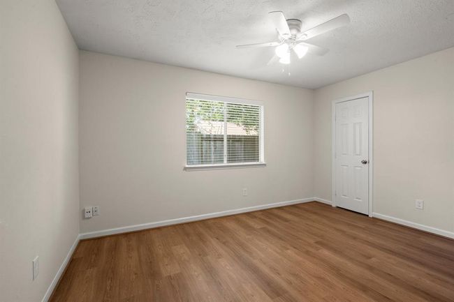 Each secondary bedroom has been fully refreshed with vinyl flooring, fresh paint, ceiling fans, updated lighting, and improved closet functionality. | Image 22