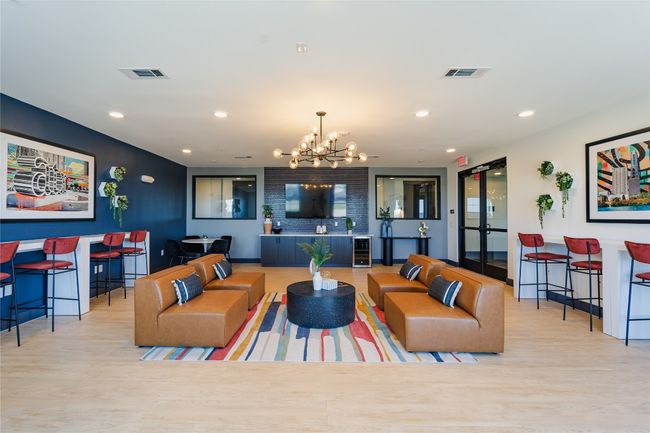 Living area with wood finished floors, visible vents, and an inviting chandelier | Image 9
