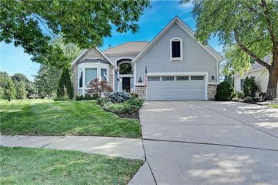 View of front facade featuring a front yard and a garage | Image 1