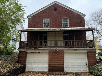 View of back facade with two garage doors and a balcony | Image 3