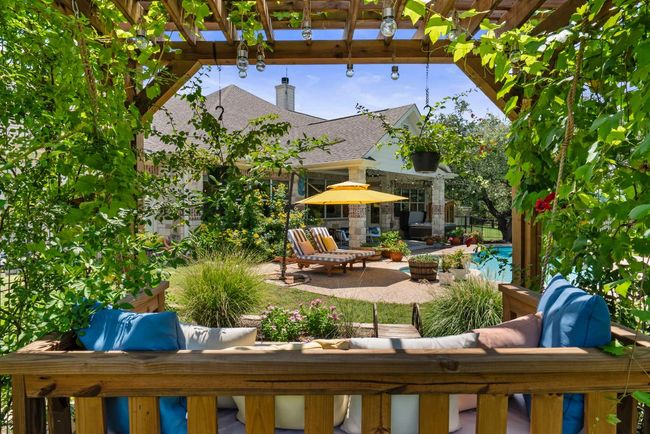 Relax in a tranquil pergola, where a daybed is nestled beneath a canopy of fragrant roses & lush grapevines. | Image 30