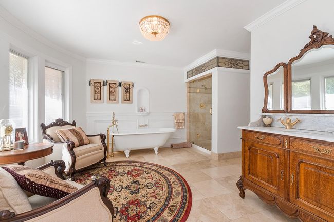 Master bath. Beautiful stained glass above the large shower. Custom antique sink/cabinet. Soaking tub with claw feet and a fancy faucet! Walk in closet! | Image 31