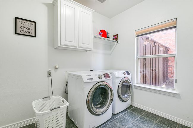 Laundry room with washing machine and dryer, cabinets, and dark tile floors | Image 28