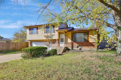 Split level home with a front yard and a garage | Image 1