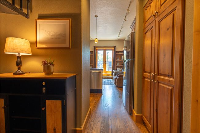 Hallway featuring wood finished floors, rail lighting, a textured wall, and a textured ceiling | Image 11