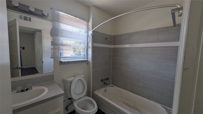 Bathroom featuring shower / bath combination, vanity, and a textured ceiling | Image 8