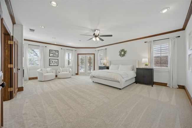The upstairs primary bedroom is gigantic and boasts an electric fireplace, sitting area and a private patio with new Trex decking. | Image 21