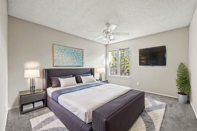 Carpeted bedroom with a textured ceiling, baseboards, and ceiling fan | Image 13