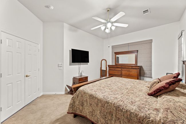 Bedroom featuring light colored carpet, baseboards, ceiling fan, and a closet | Image 29