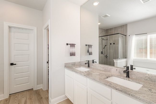 Primary bath featuring, soaking tub, separate shower, double vanity, wood finished floors. | Image 15