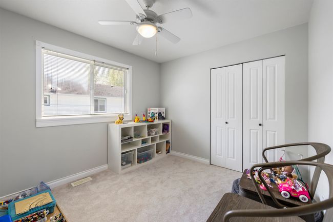 Interior space featuring baseboards, a ceiling fan, carpet flooring, and visible vents | Image 19