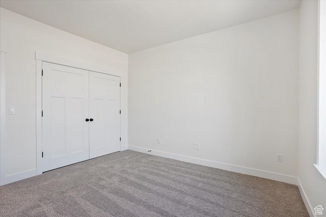 Unfurnished bedroom with a closet, carpet flooring, and baseboards | Image 14