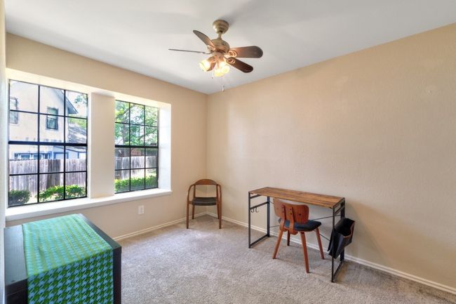 Secondary bedroom #1 is spacious and features a window seat and ceiling fan with a generously sized closet. | Image 19