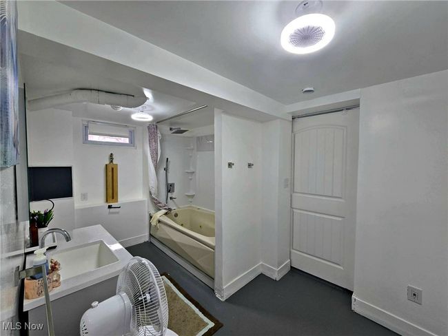Full bath with vanity, a combined bath / shower with jetted tub, and baseboards | Image 49