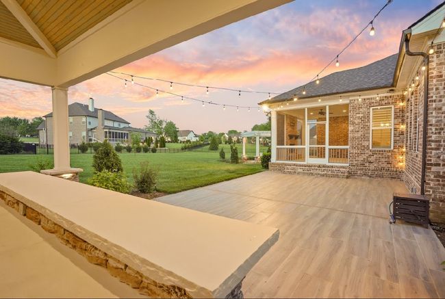 Love to entertain? Look no further—this backyard was made for it! With a spacious patio, string lights, outdoor kitchen, and seamless flow to the screened-in porch, it’s the ultimate setup for hosting in style. | Image 12