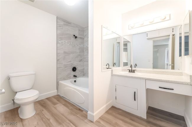 Bathroom with wood finished floors, vanity, and bathtub / shower combination | Image 18