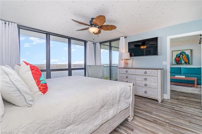 OWNER'S SUITE SHOWING DIRECT ENTRANCE TO LANAI AND ENTRANCE TO MAIN LIVING AREA. WALL-MOUNTED FLAT SCREEN TV. KING BED. | Image 13