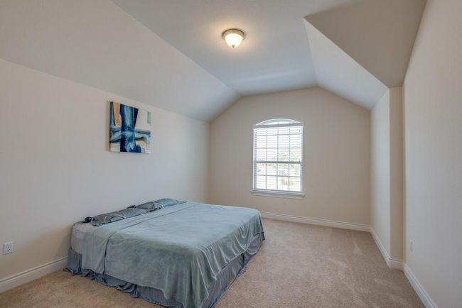 Bedroom featuring carpet flooring, baseboards, and lofted ceiling | Image 21