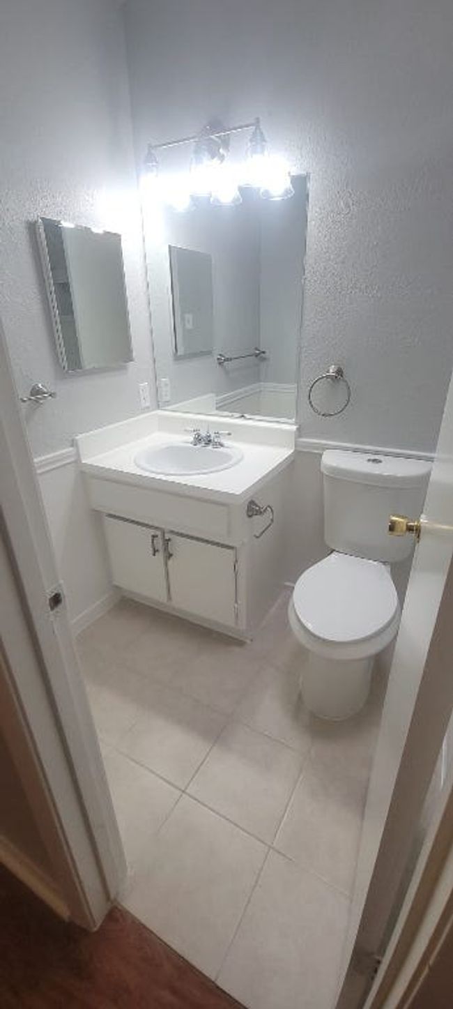 Bathroom featuring vanity, tile patterned floors, and a textured wall | Image 12