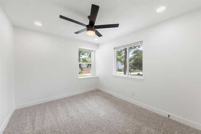 Additional bedroom (2) located upstairs features plush carpet, nice natural light, ceiling fan, and canned lights. | Image 21