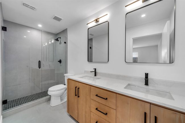 Bathroom with toilet, a shower stall, double vanity, and tile patterned flooring | Image 25