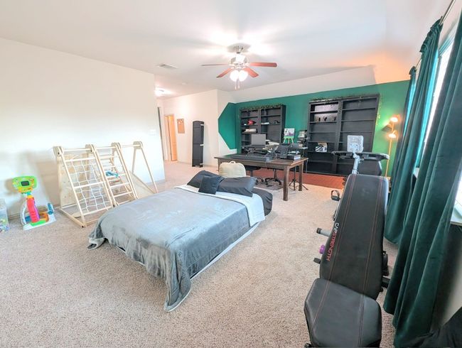Carpeted bedroom with a ceiling fan | Image 7