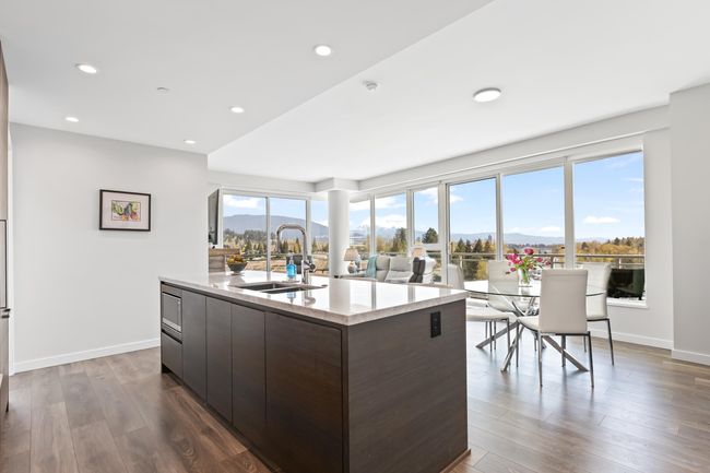 Kitchen featuring modern cabinets, a center island with sink, a sink, and a mountain view | Image 6
