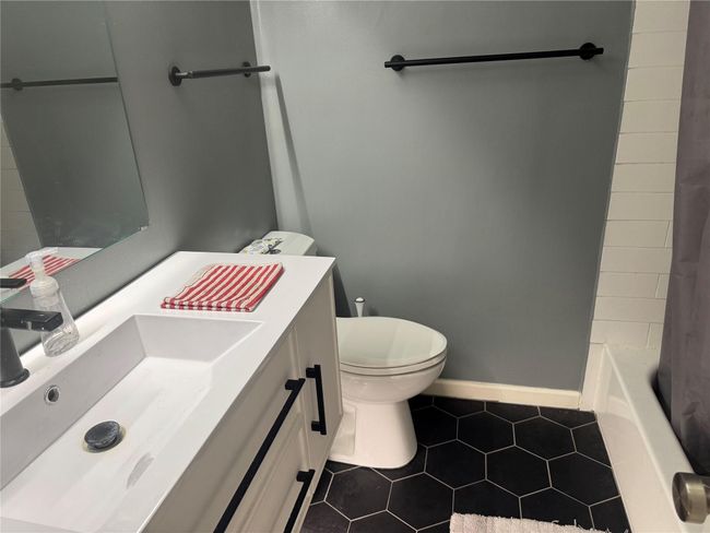 Full bath featuring tile patterned flooring, vanity, toilet, baseboards, and shower / tub combo | Image 11