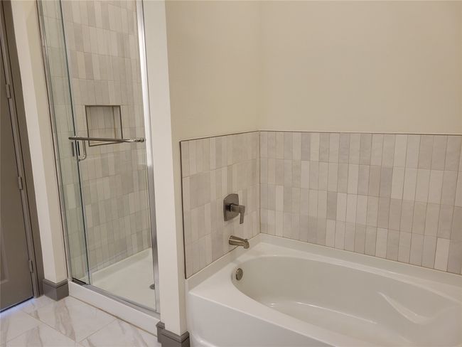 Bathroom with a garden tub, a stall shower, and marble finish floors | Image 14