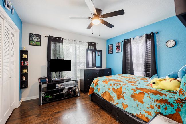 Bedroom featuring a closet, ceiling fan, baseboards, and wood finished floors | Image 21