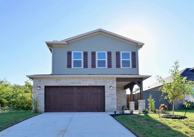 View of front facade with a front lawn and a garage | Image 1