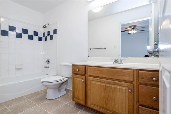 Bathroom with vanity, tile patterned flooring, tub / shower combination, and a ceiling fan | Image 15