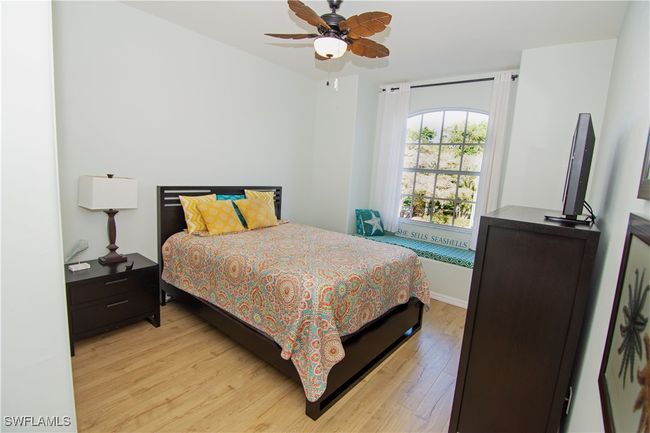 Large second bedroom with attached bath features a double closet a ceiling fan and attractive flooring. | Image 17