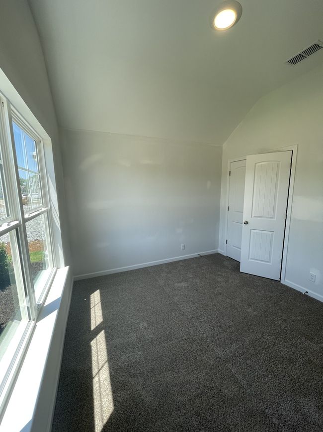 secondary bedroom with vaulted ceilings | Image 17