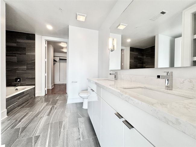 Full bath featuring double vanity, toilet, a garden tub, recessed lighting, and baseboards | Image 18