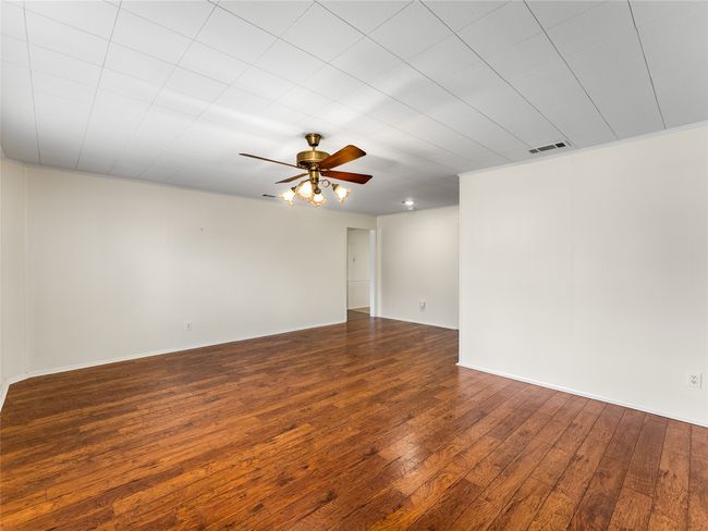 Empty room featuring hardwood / wood-style flooring and ceiling fan | Image 9