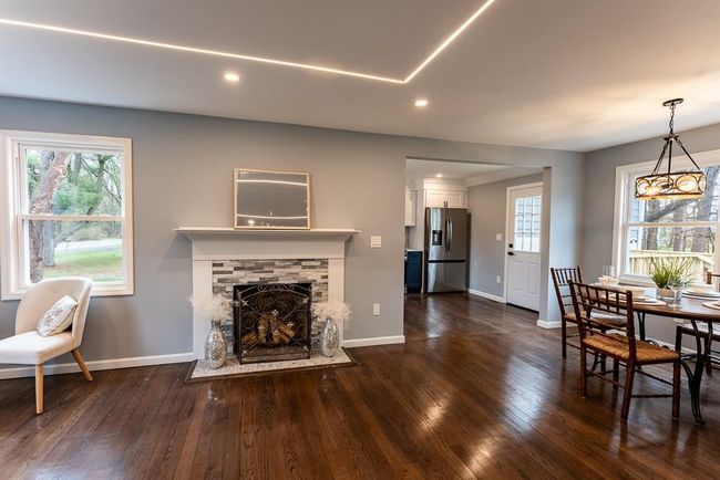 Living area with baseboards, a wealth of natural light, a fireplace, and dark wood finished floors | Image 5