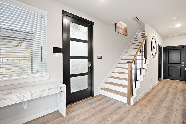 Entryway featuring light wood-style floors, plenty of natural light, and stairs | Image 6