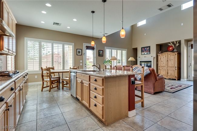 Kitchen with a sink, a breakfast bar area, appliances with stainless steel finishes, open floor plan, and visible vents | Image 22