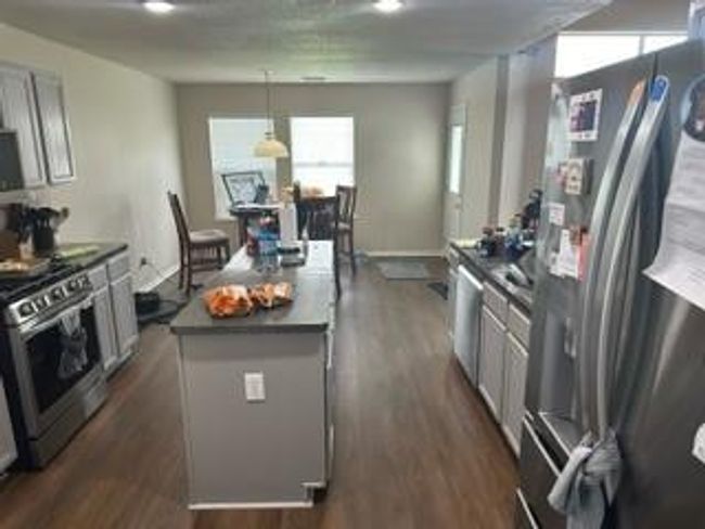Modern kitchen featuring sleek stainless steel appliances, ample counter space, and a cozy dining area with abundant natural light. Perfect for both cooking and entertaining. | Image 6