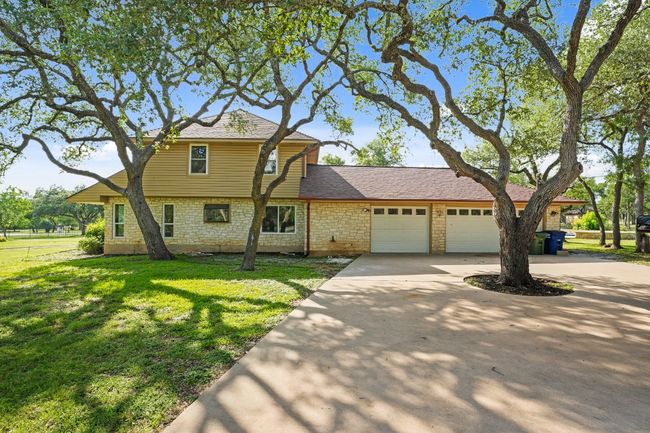 View of front of house featuring a garage, driveway, a front lawn, and roof with shingles | Image 34