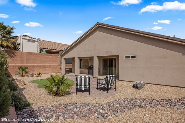 Rear view of house with a putting green, a patio, and stucco siding | Image 53