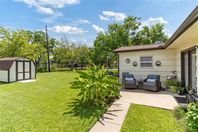 Relax on the cozy back porch overlooking the large, fully fenced backyard—ideal for outdoor gatherings, gardening, or simply enjoying your private outdoor space. | Image 20