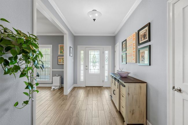 Foyer featuring crown molding, a healthy amount of sunlight, and light wood finished floors | Image 9