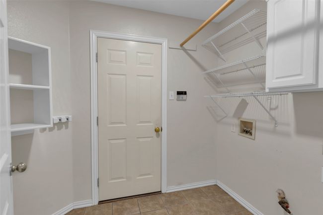 Laundry room with washer hookup, cabinet space, and light tile patterned flooring | Image 23