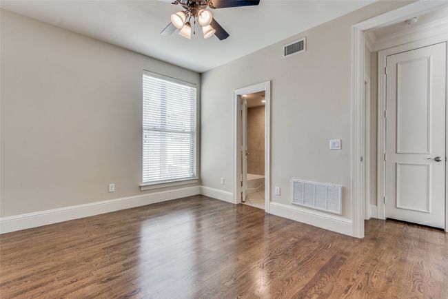 Unfurnished bedroom featuring wood finished floors, ceiling fan, and ensuite bath | Image 10