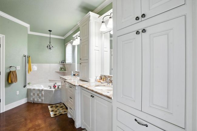 Bathroom featuring vanity, a garden tub, concrete flooring, and crown molding | Image 17