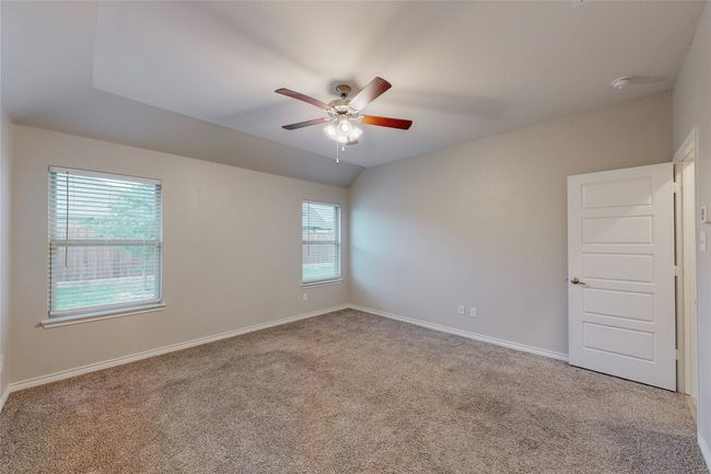 Unfurnished room featuring a ceiling fan, lofted ceiling, carpet floors, and baseboards | Image 34
