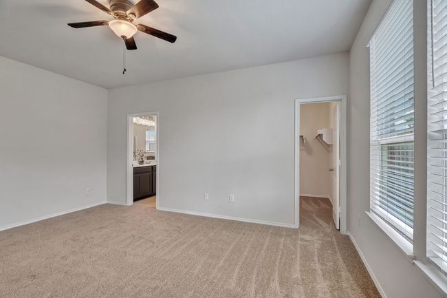 Empty room with light carpet, healthy amount of natural light, and a ceiling fan | Image 18
